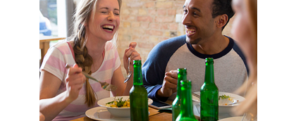 een stel vrienden aan het eten met wat biertjes op tafel