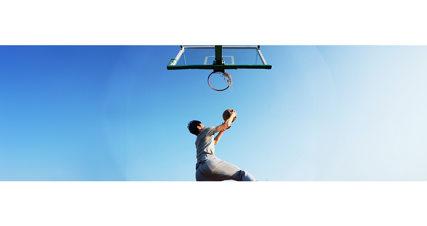 man die buiten basketball speelt met een blauwe lucht