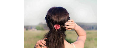 vrouw staat in veld met rug naar camera toe