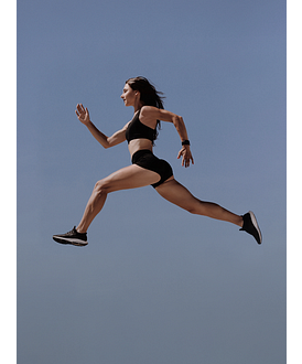 een vrouw springt in de lucht in sportkleding