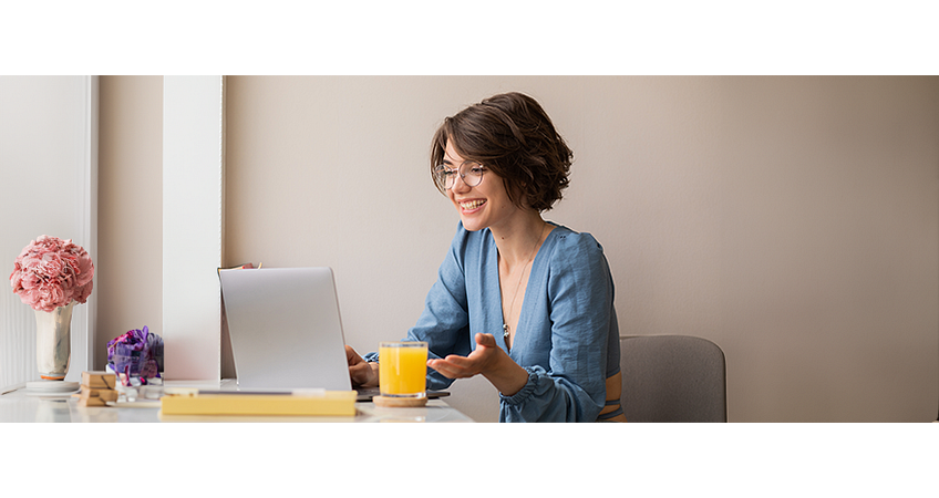 Lachende, energieke vrouw aan het werk achter haar bureau