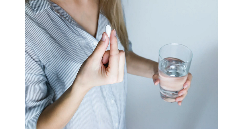 vrouw met tablet diclofenac en glas water vrouw met tablet diclofenac en glas water