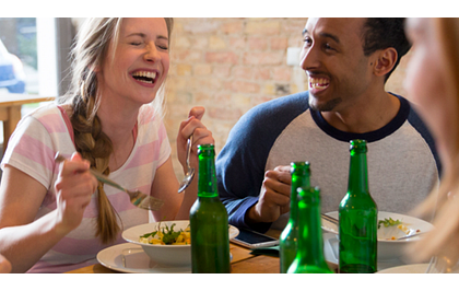 een stel vrienden aan het eten met wat biertjes op tafel een stel vrienden aan het eten met wat biertjes op tafel