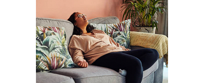 vrouw zit futloos op de bank zonder energie