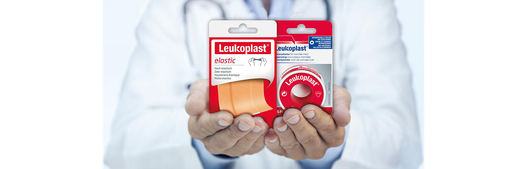 Dokter met Leukoplast elastic en Leukoplast product in handen Dokter met Leukoplast elastic en Leukoplast product in handen