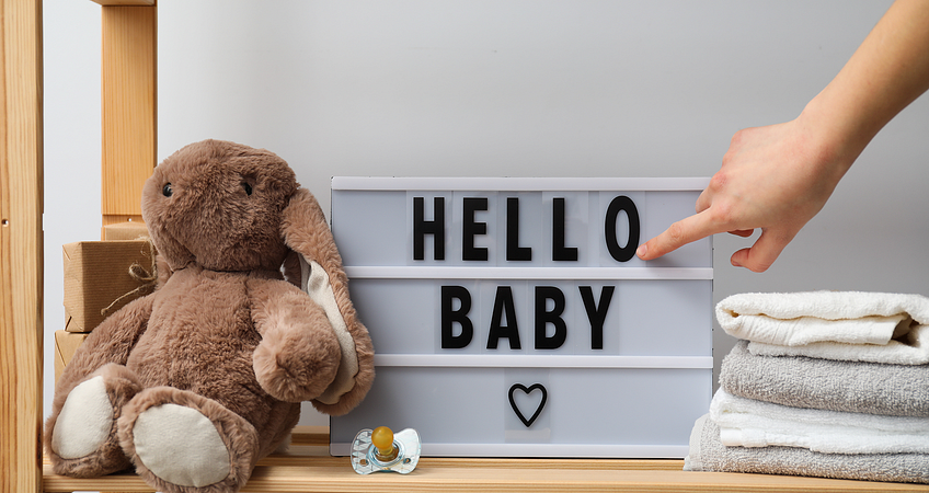 een bord met hello baby erop met een konijnen knuffel ernaast een bord met hello baby erop met een konijnen knuffel ernaast