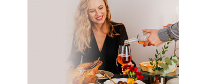 vrouw die tijdens de kerst eet en drinkt met veel lekkers op tafel