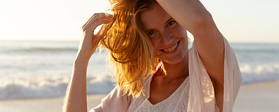 vrouw op het strand met handen in haar haar