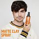 American Crew Matte Clay Spray 150ML man met mooi haar en het flesje in zijn hand