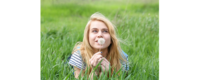 vrouw liggend in gras met paardebloem vrouw liggend in gras met paardebloem