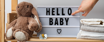 een bord met hello baby erop met een konijnen knuffel ernaast een bord met hello baby erop met een konijnen knuffel ernaast
