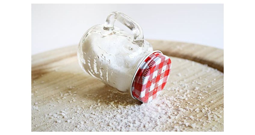 pot met zout gestrooid over een houten plankje